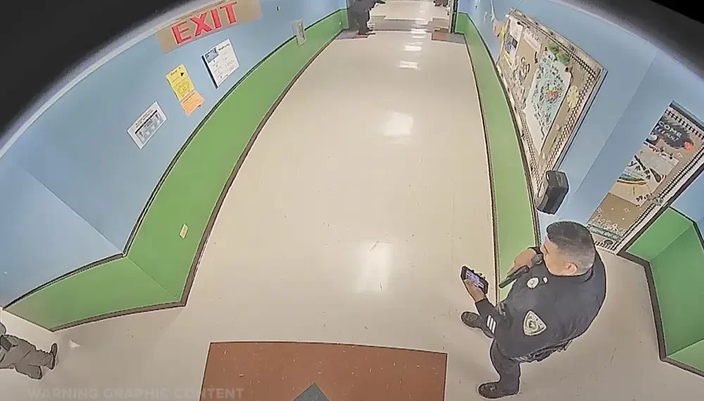 Policía revisando el teléfono en video de masacre de Uvalde, esperaba noticias de su esposa Eva Mireles, la maestra asesinada